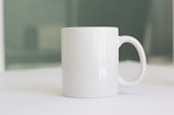 a white coffee mug sitting on top of a table