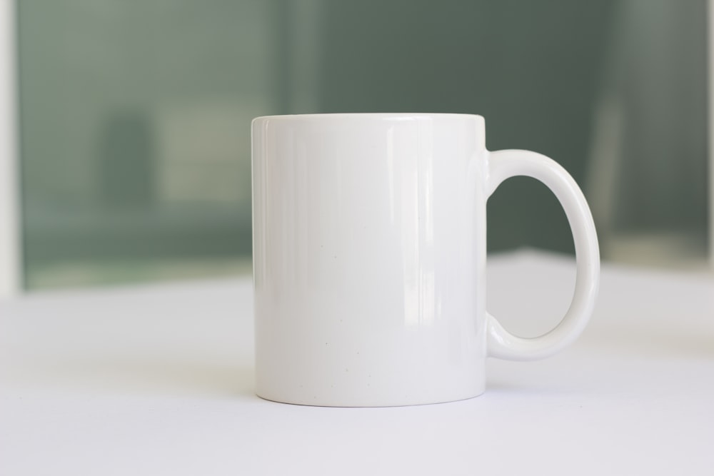 una tazza di caffè bianco seduta sopra un tavolo