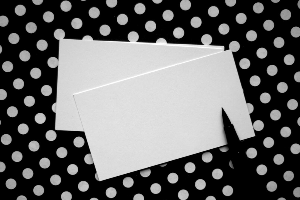 two pieces of white paper sitting on top of a table