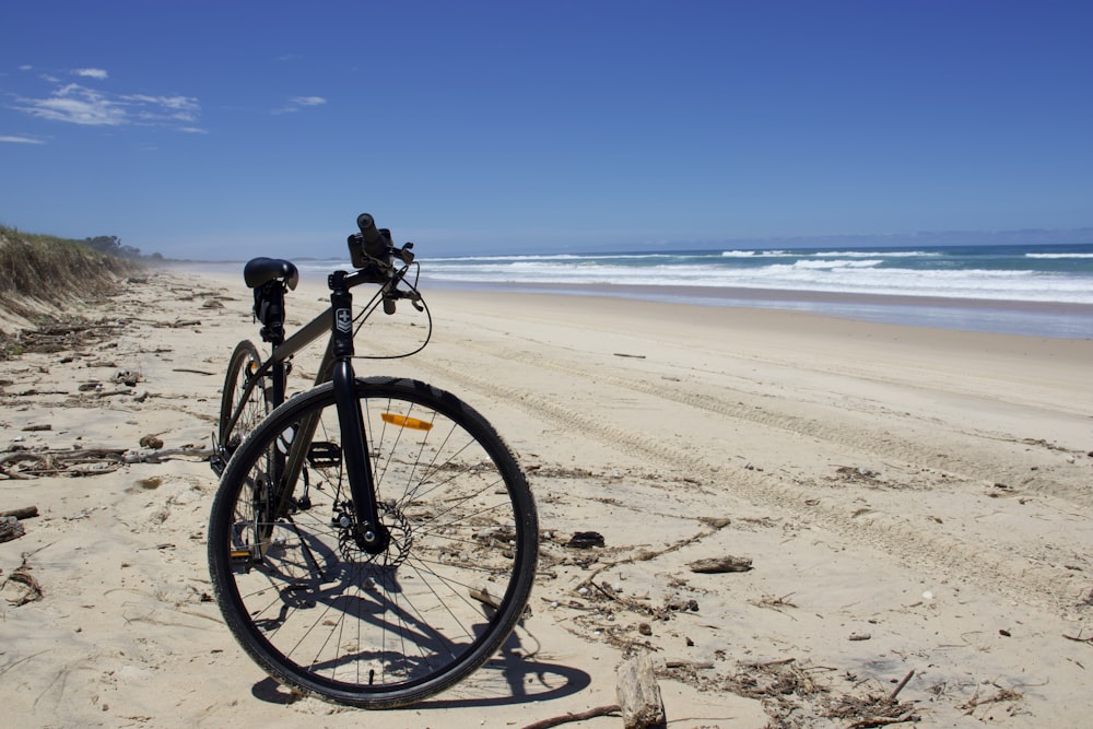 a bicycle parked on the beach next to the ocean