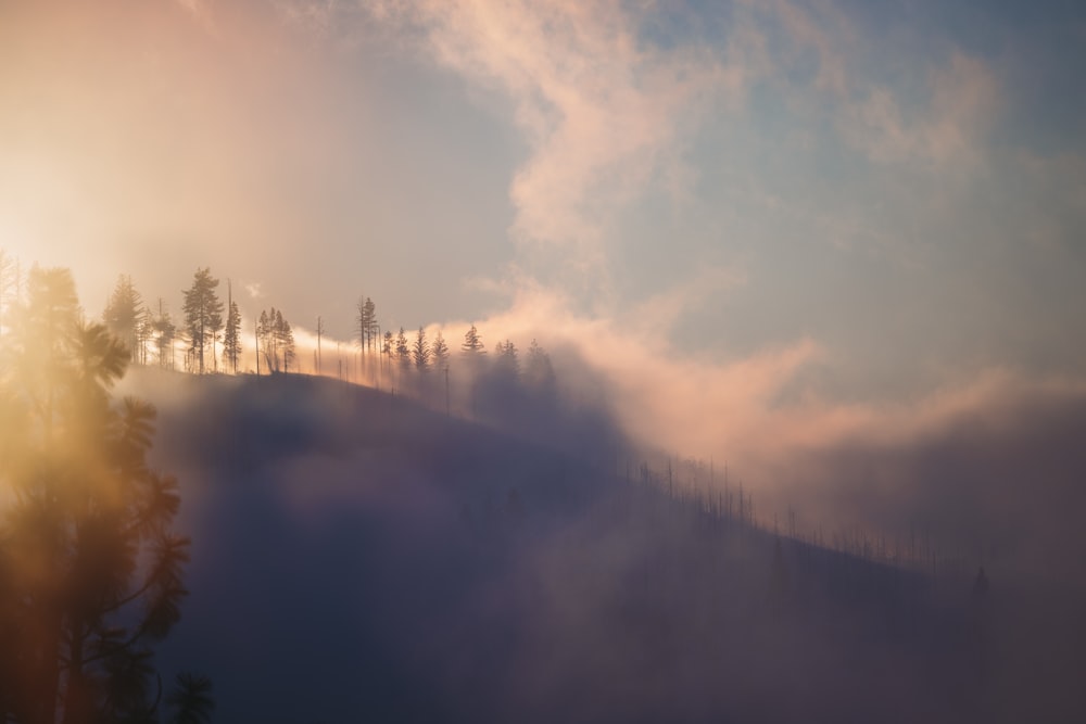 the sun shines through the clouds in the mountains