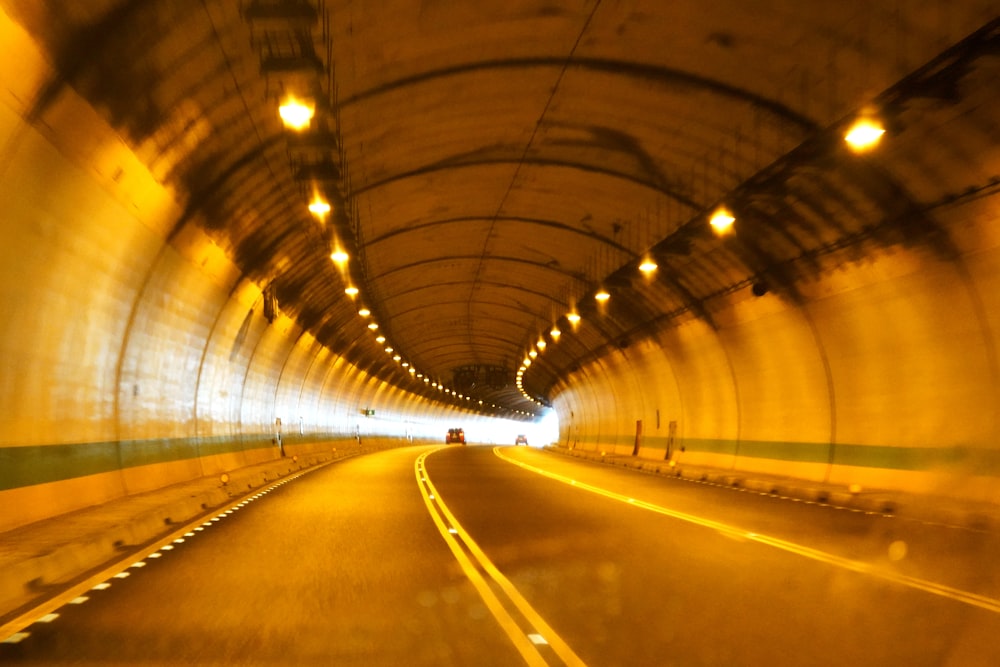 a car driving through a tunnel with lights on
