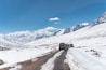 a truck driving down a snow covered road