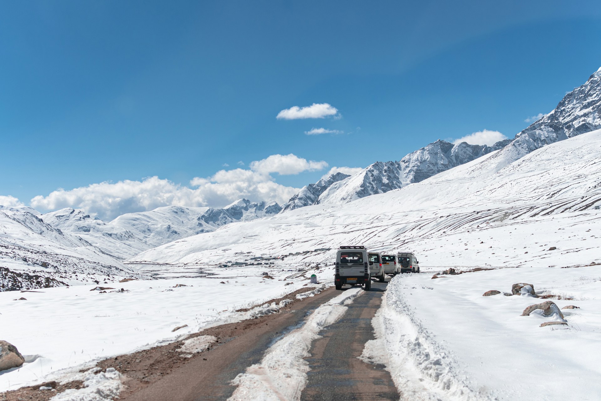 a truck driving down a snow covered road