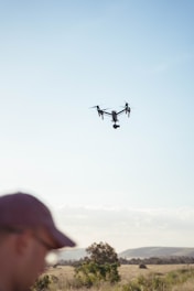 a man standing in a field looking at a flying object