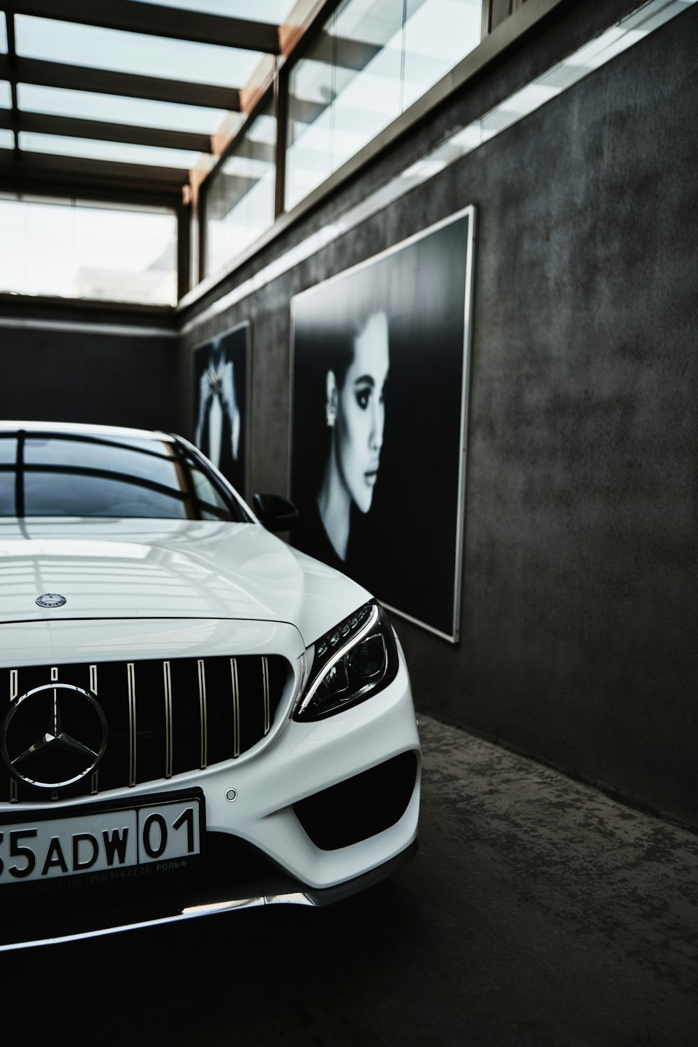 a white car parked in front of a black wall