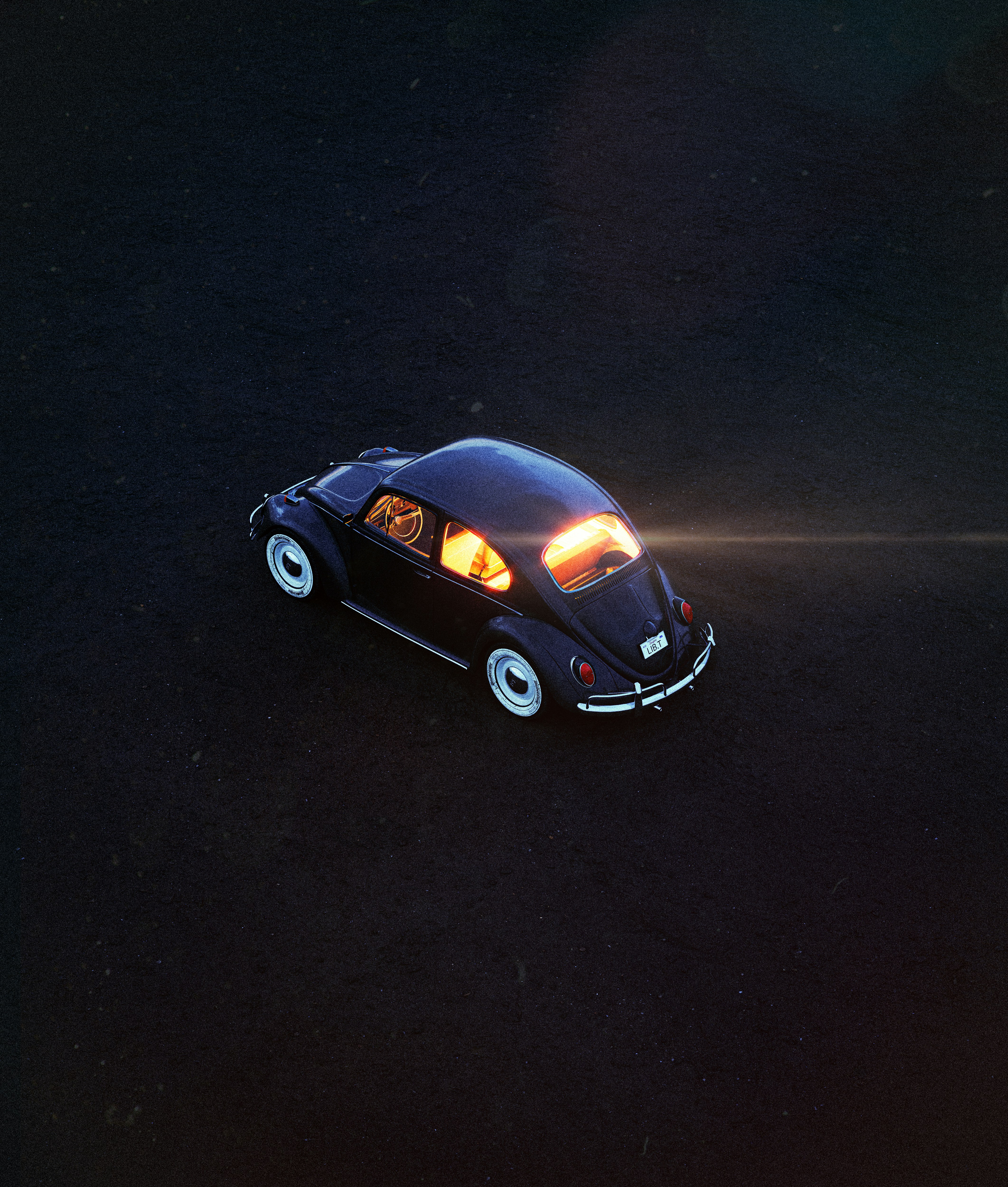 a small black car with its lights on