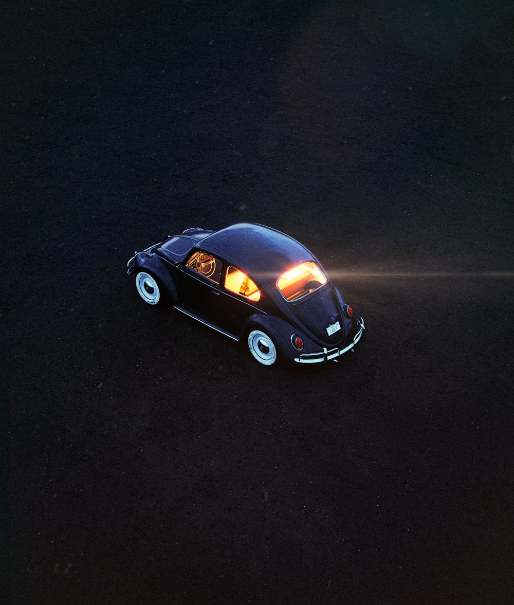 a small black car with its lights on
