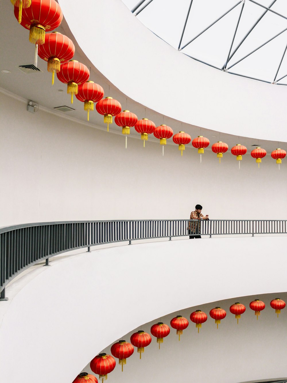 a person standing on a balcony with red lanterns