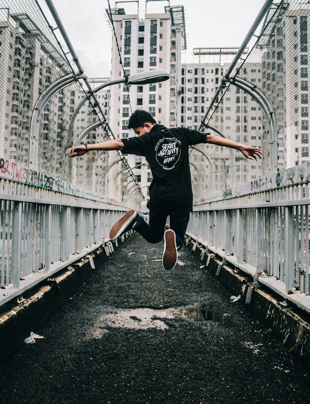 a man jumping in the air on a bridge