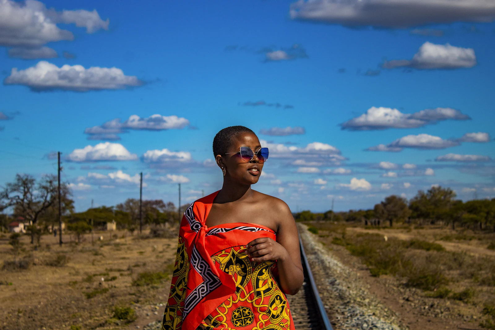 A woman in a printed wrap by the railway near Siteki — Eswatini