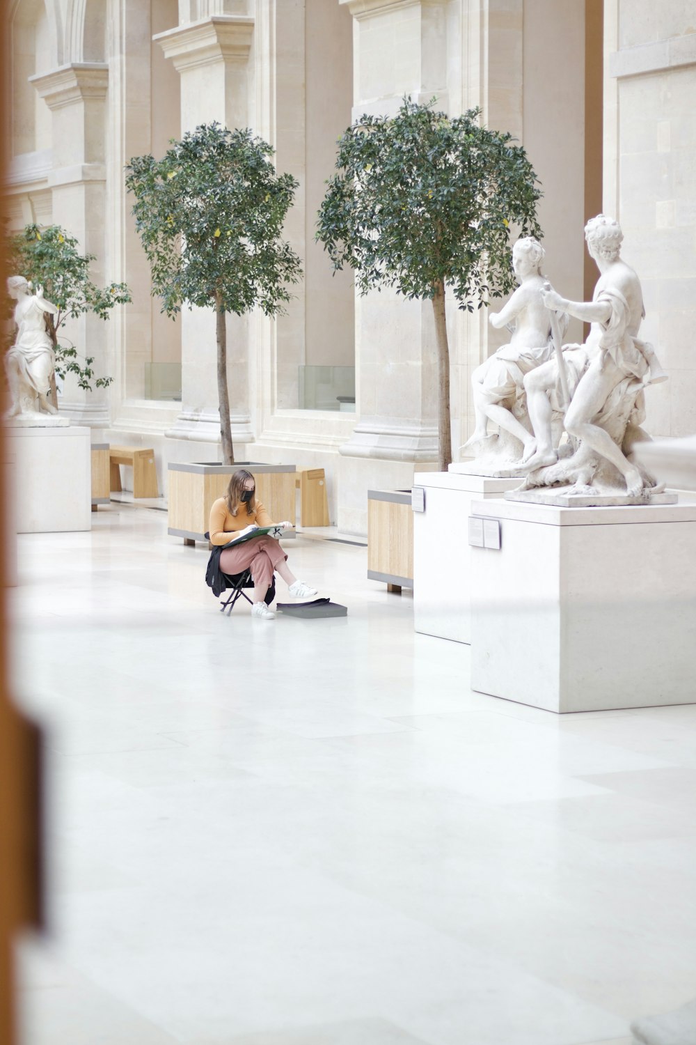 a woman sitting on the ground in a museum