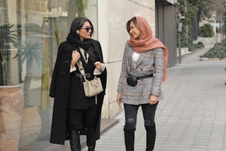 two women walking down a sidewalk next to each other