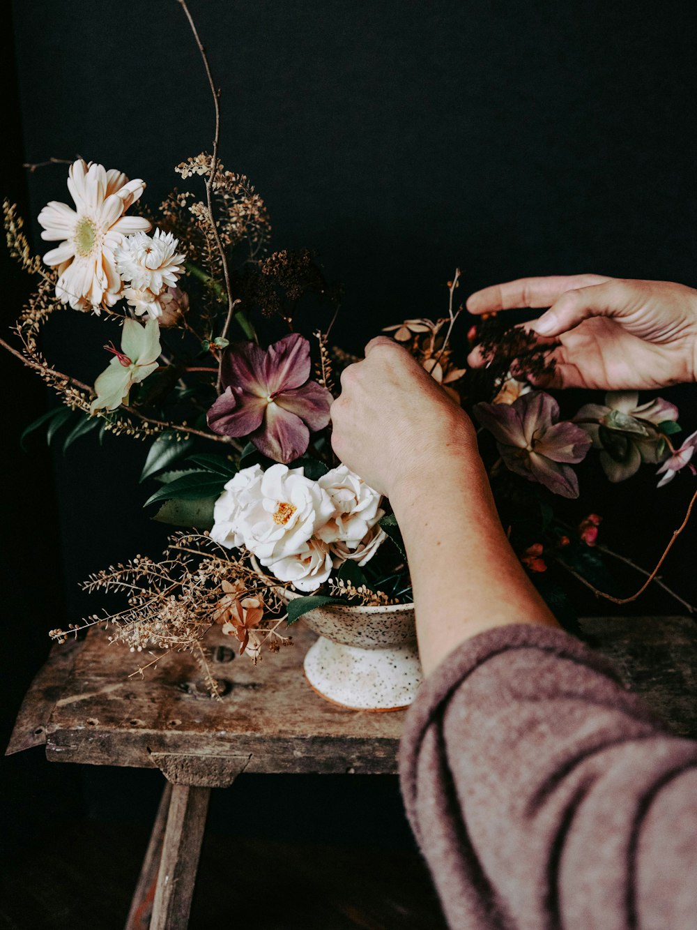 a woman is arranging flowers on a table