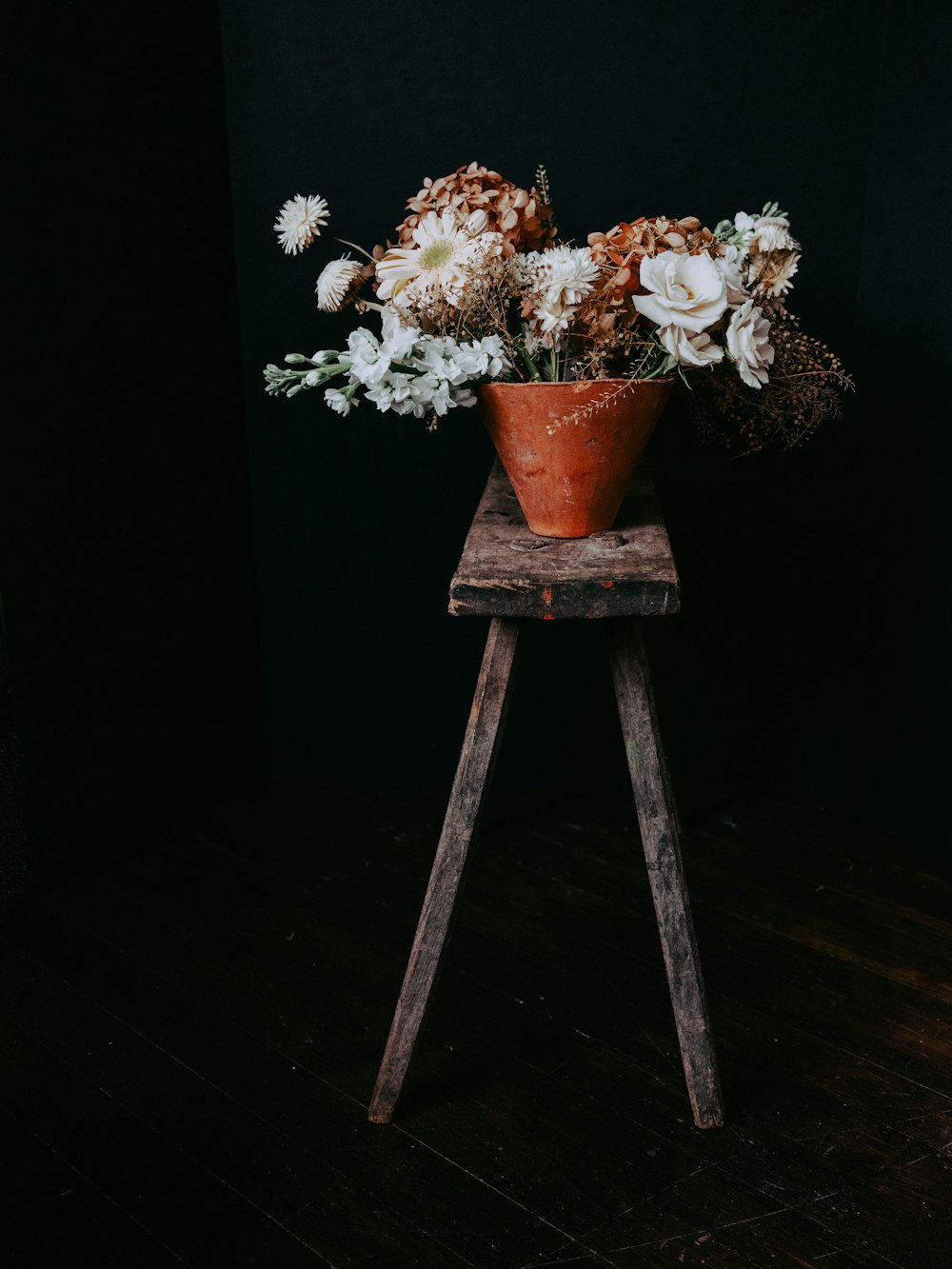 a flower pot sitting on top of a wooden stand