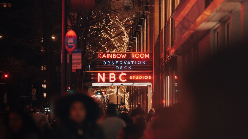 a crowd of people walking down a street at night