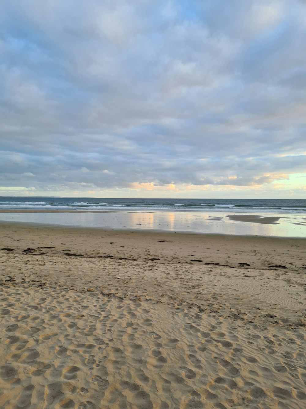 a person riding a surfboard on a sandy beach