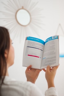 a woman is reading a book in a room