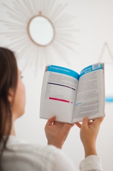 a woman is reading a book in a room