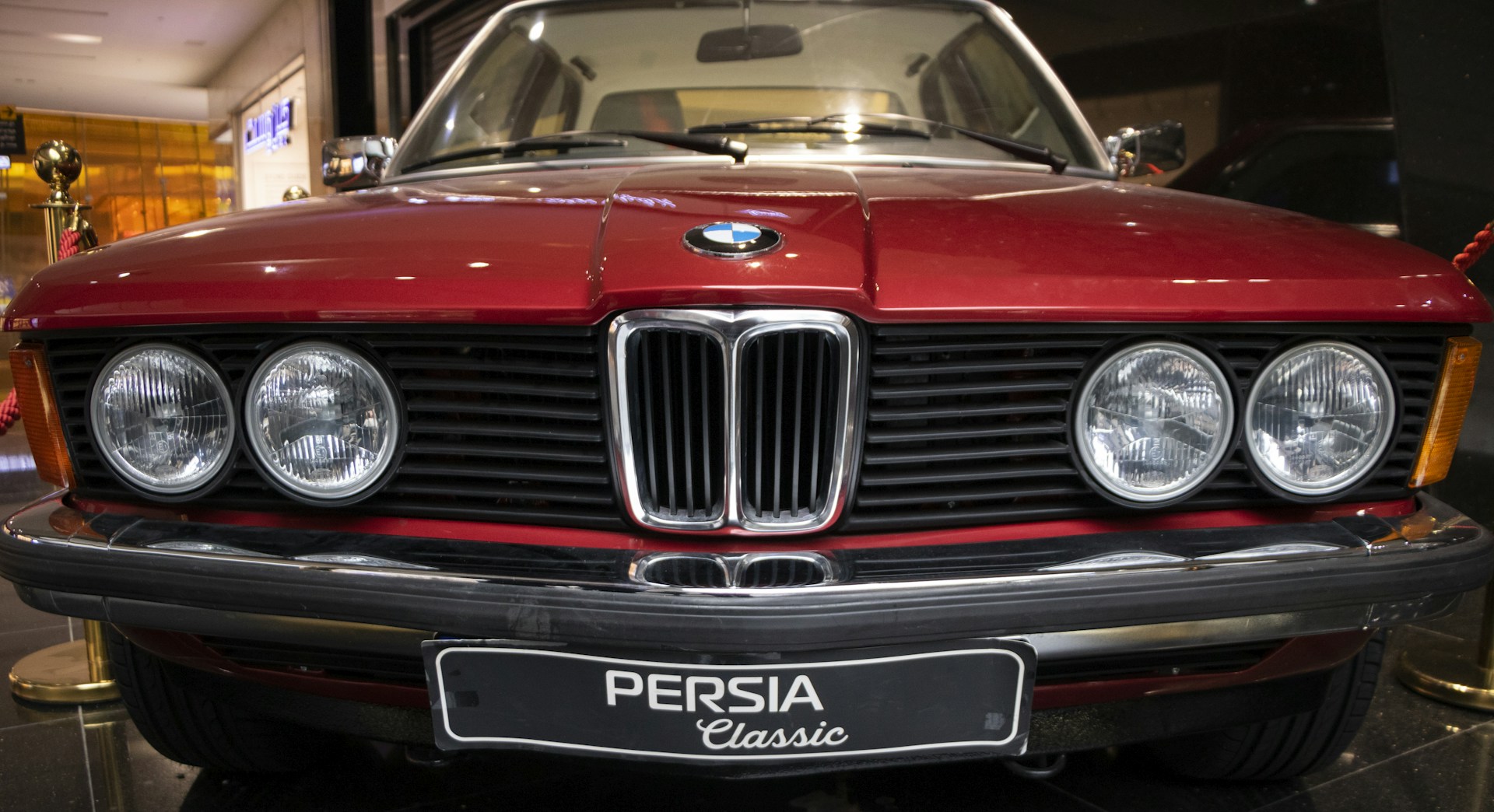 a red car is parked in a showroom