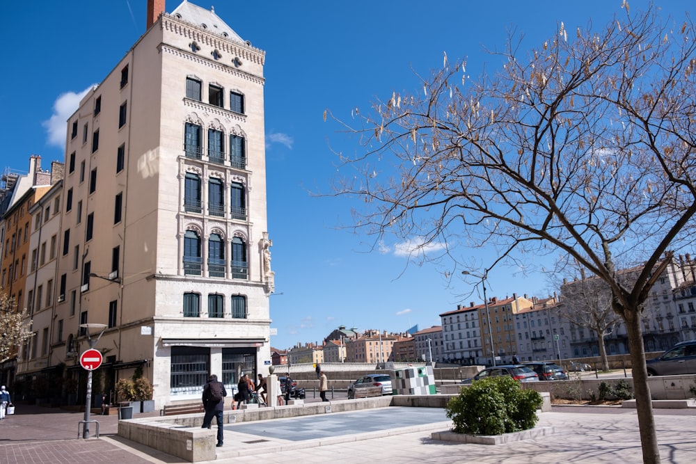 a tall white building sitting next to a tree