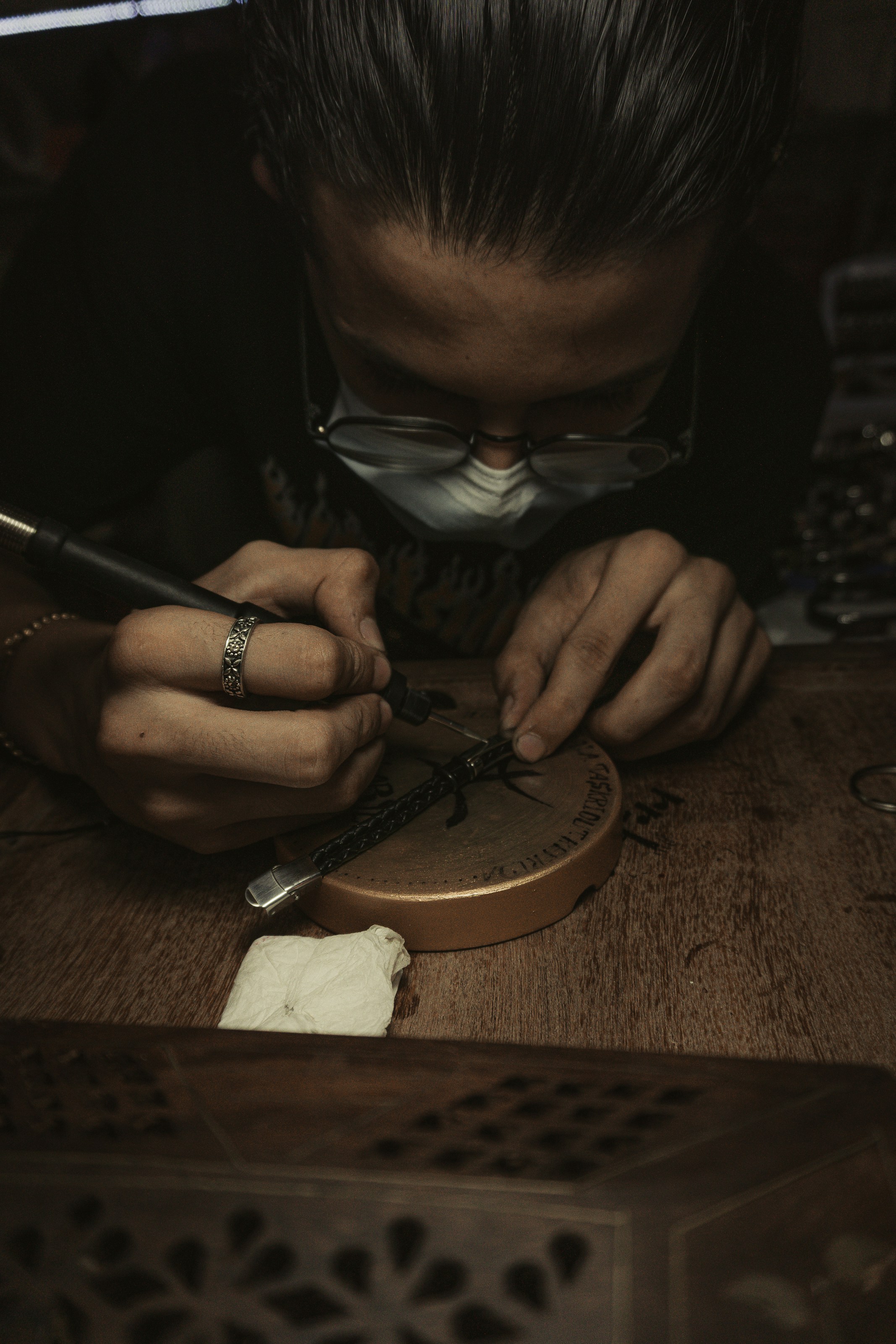 a man in a black shirt is working on a piece of wood