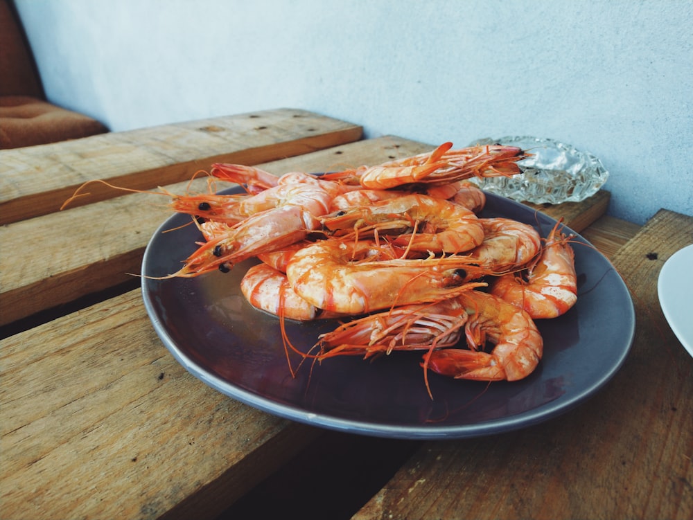 a plate of shrimp on a wooden table
