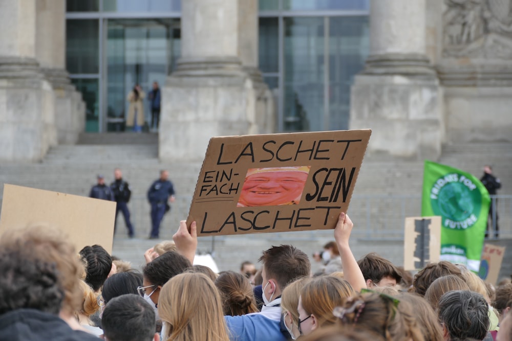 a group of people holding up signs in front of a building