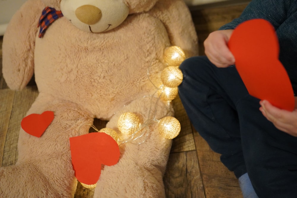 a large teddy bear sitting on a wooden floor