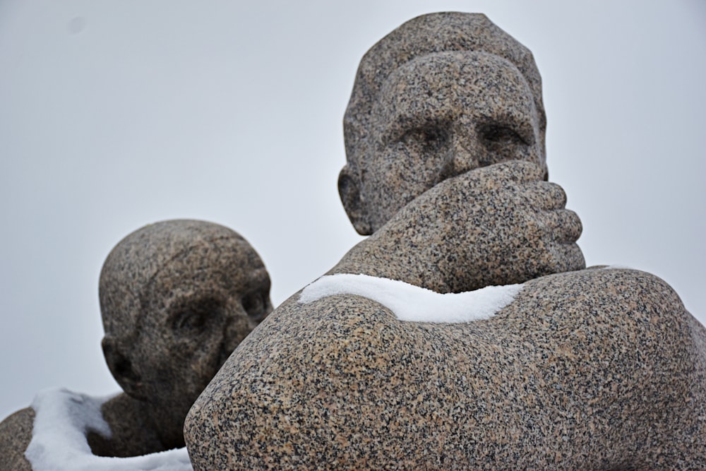 a statue of a man with his hands on his face