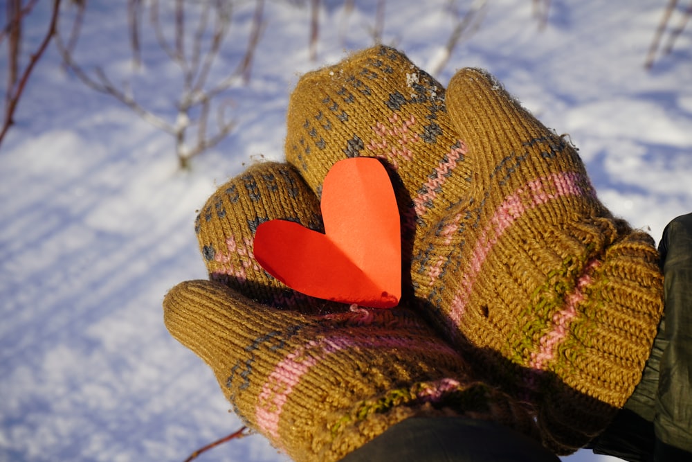 a glove with a heart on it in the snow