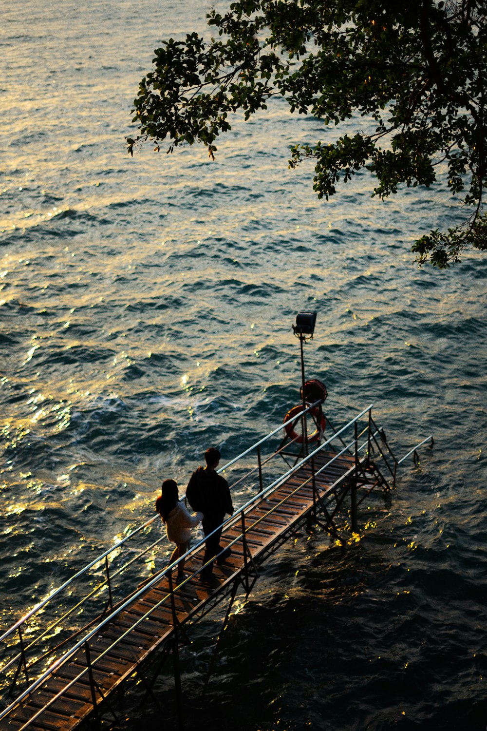 a couple of people that are standing on a pier