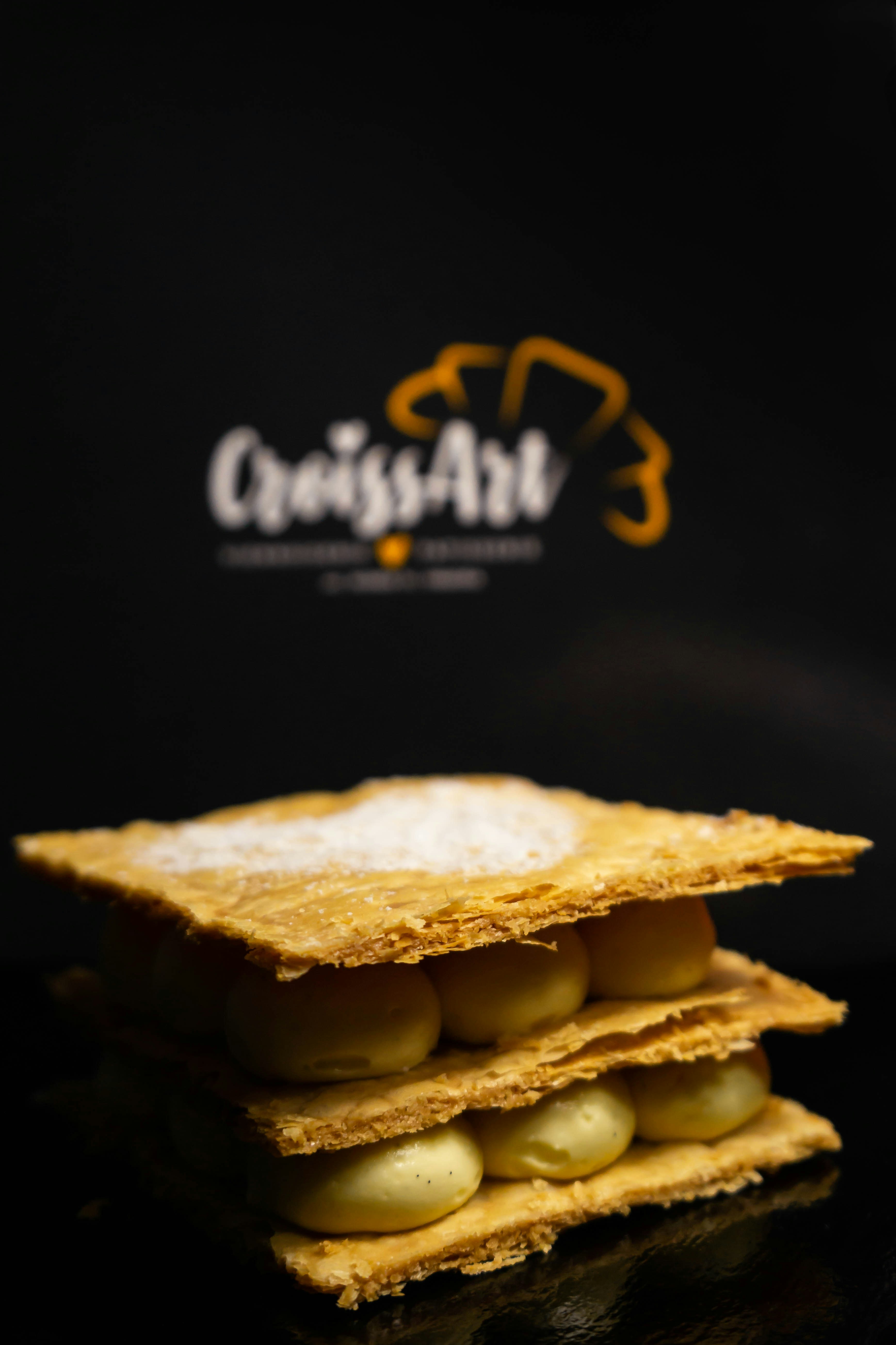 Golden mille-feuille pastry with caramel cream and chocolate glaze on marble surface
