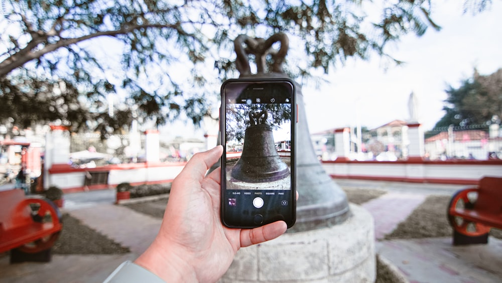 a person taking a picture of a bell