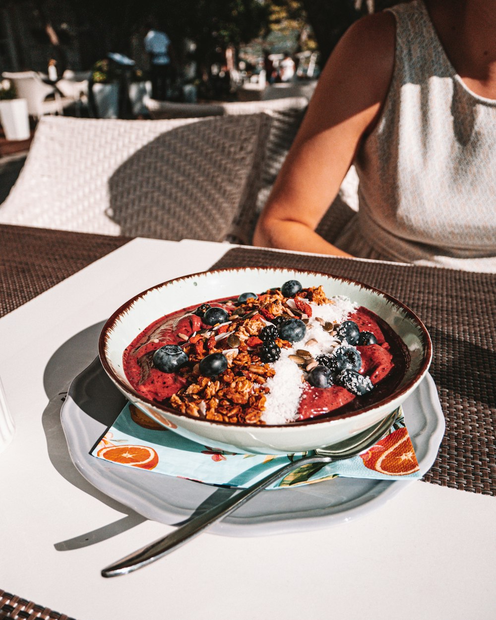 un bol de flocons d’avoine avec des bleuets et du granola sur une table