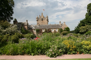 a large building surrounded by lots of trees and flowers