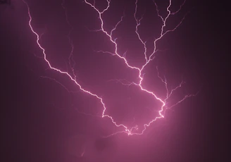 A dramatic black-and-white still from a recent audiovisual campaign featuring dynamic lightning effects.
