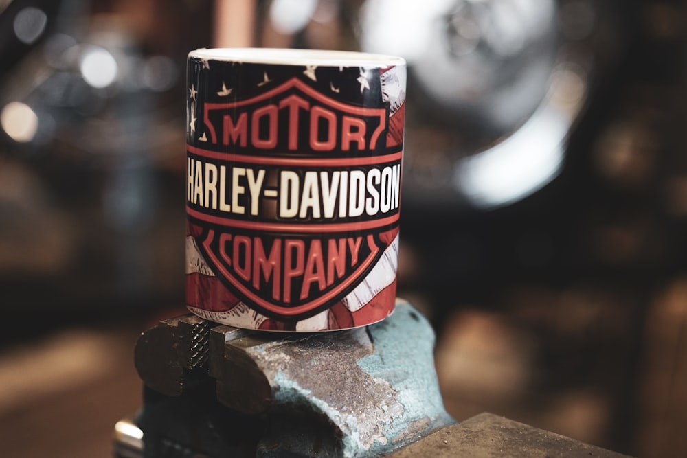 a harley davidson coffee mug sitting on top of a piece of metal