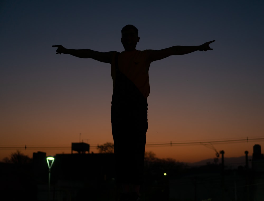 a silhouette of a man with his arms outstretched