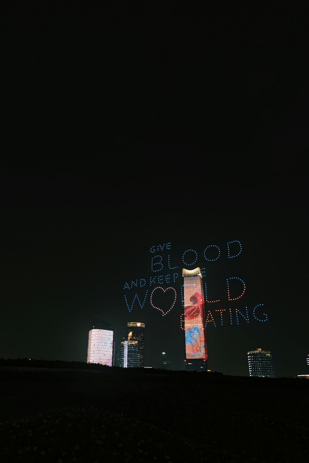 a city skyline at night with a message projected in the sky