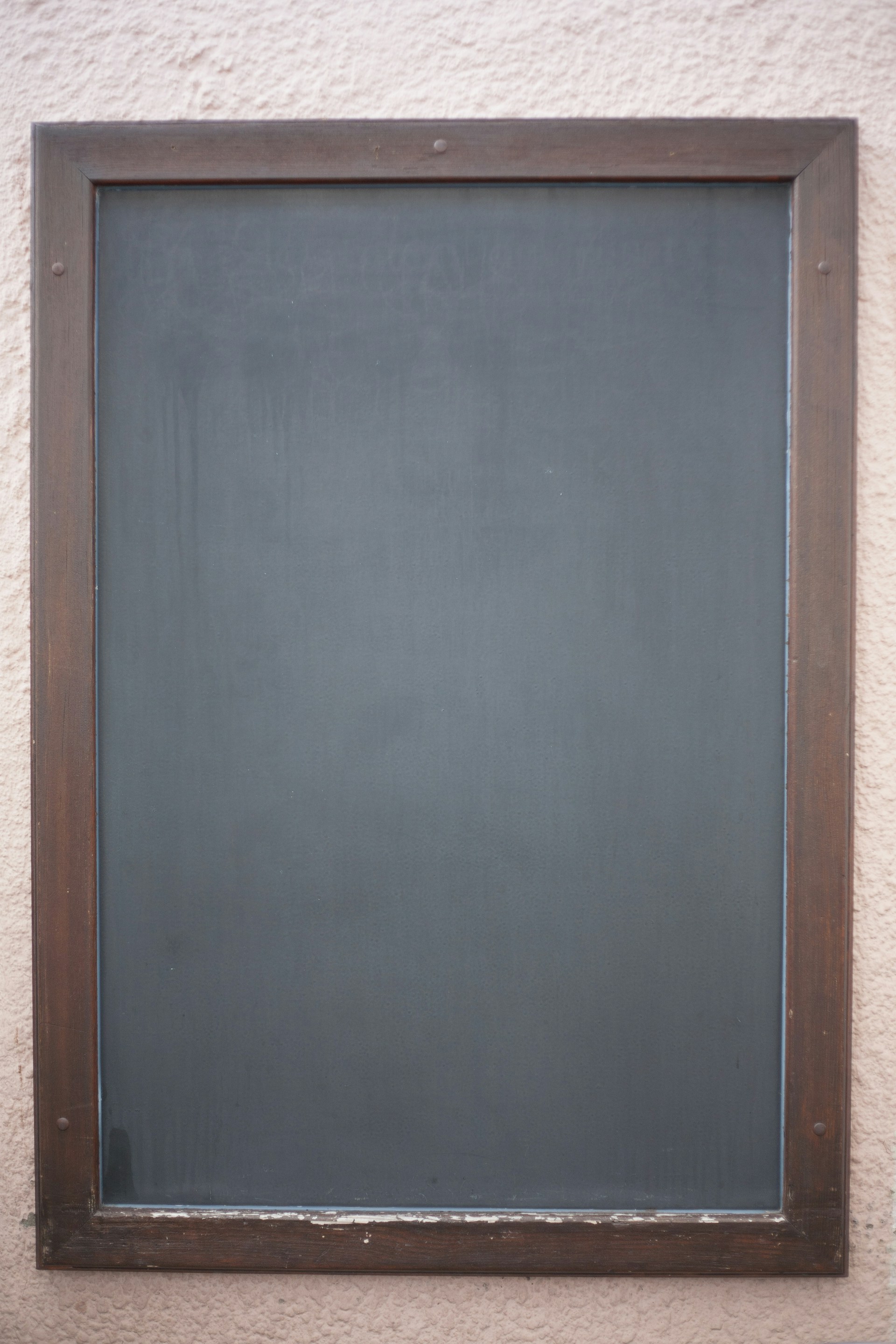 a blackboard mounted to the side of a building