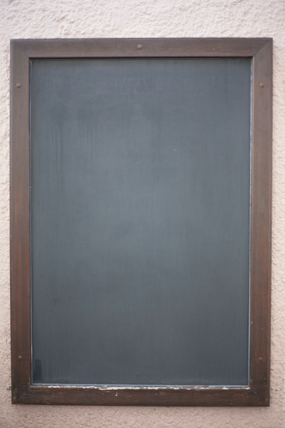 a blackboard mounted to the side of a building