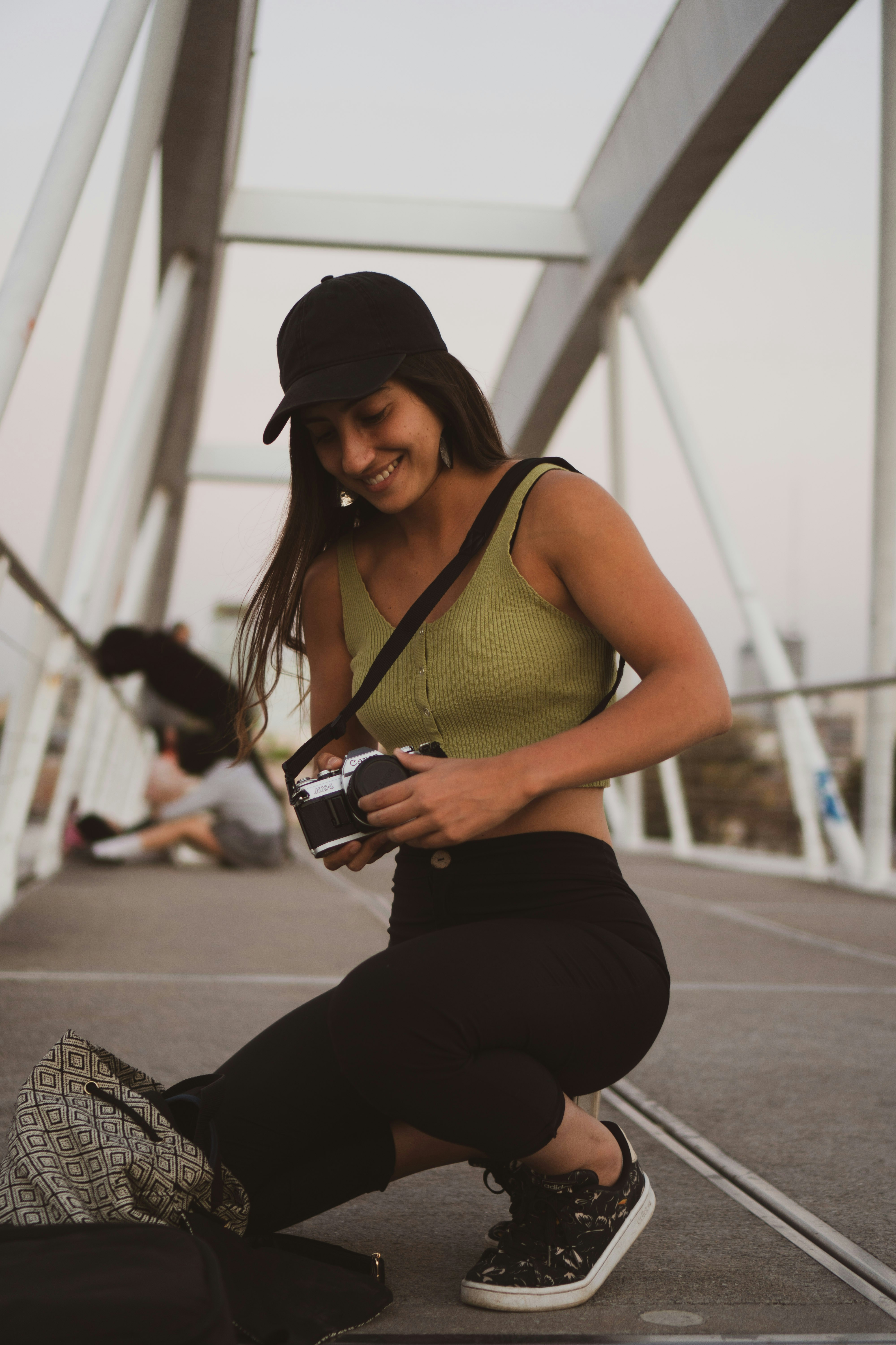 a woman kneeling down while holding a camera