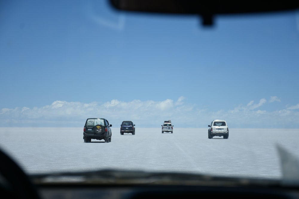 a group of cars driving across a salt flat