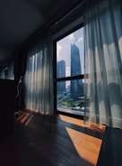 Large glass windows covered with elegant sun-screen curtains