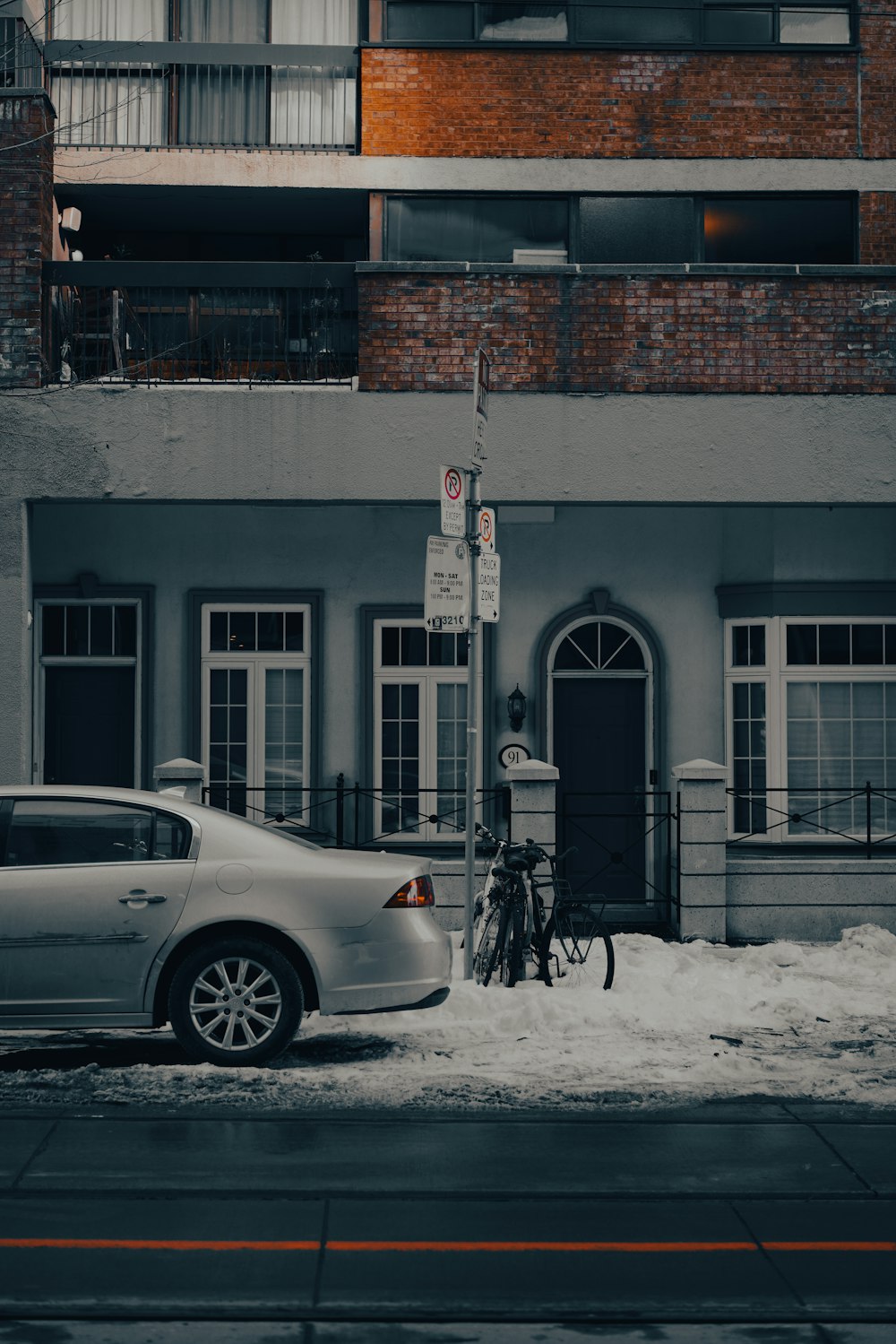 a car parked in front of a building on a snowy street