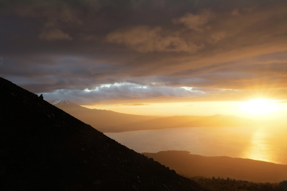 a person standing on top of a mountain at sunset