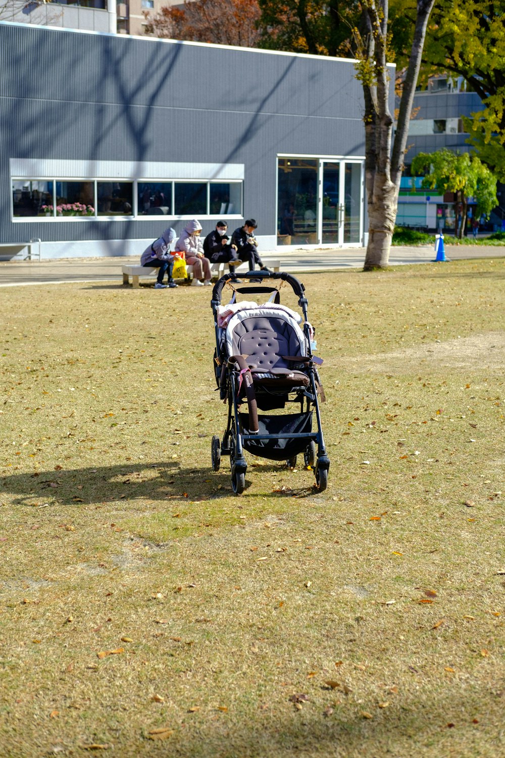 a stroller sitting in the grass in front of a building