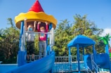 a couple of kids standing on top of a slide
