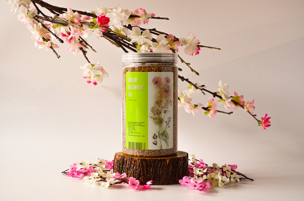 a jar of tea sitting on top of a tree stump